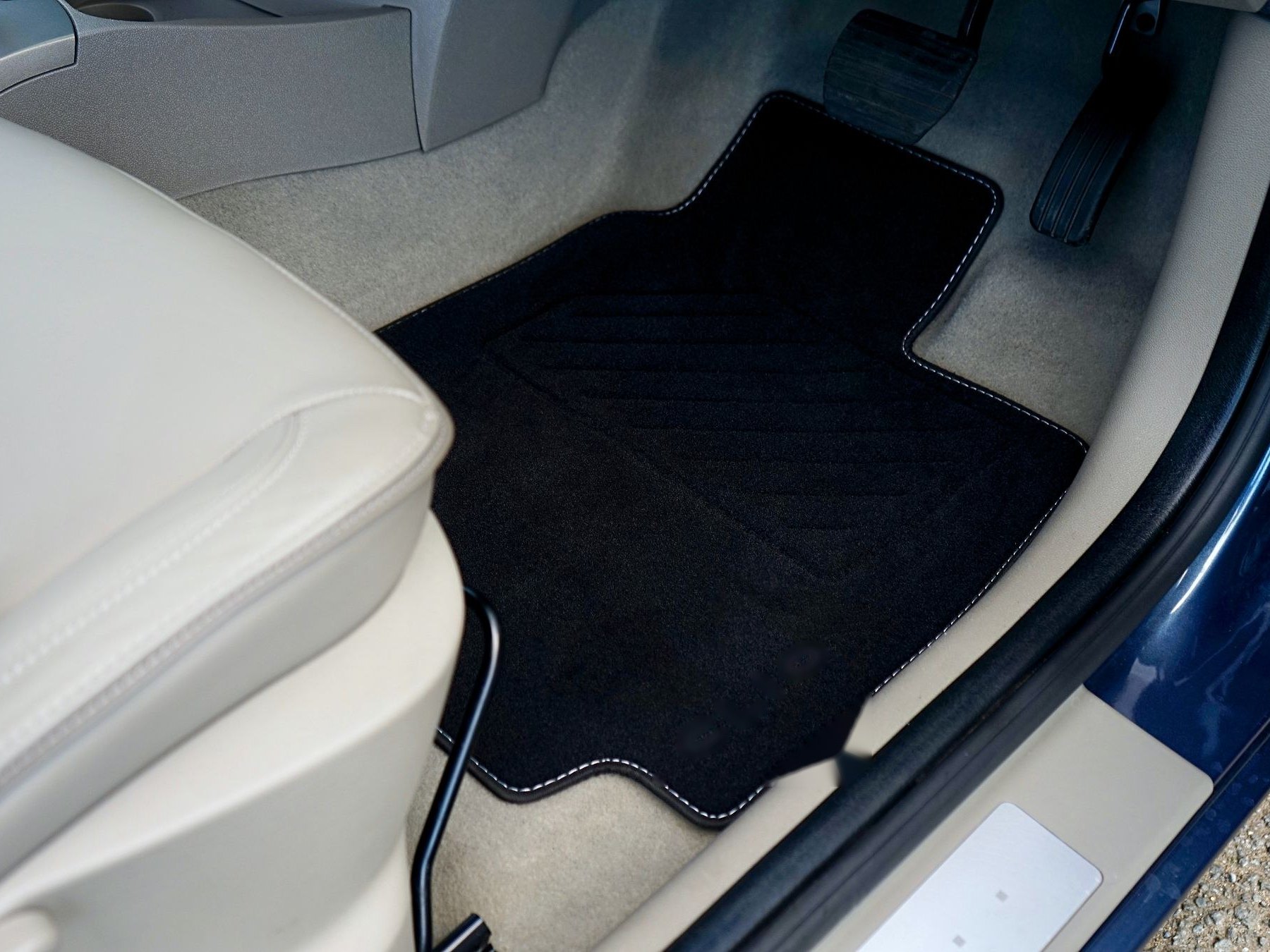 Fitted textile floor mat in a car footwell — representative image