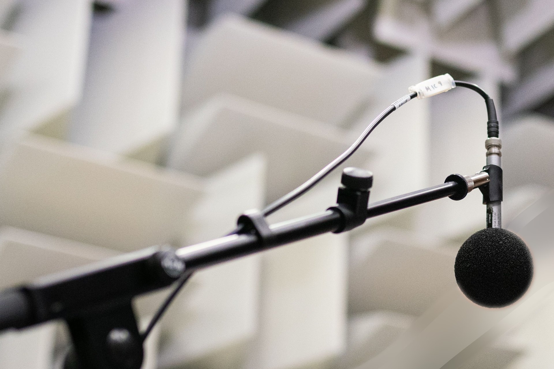 Measurement microphone on a boom inside an acoustic test chamber — representative image