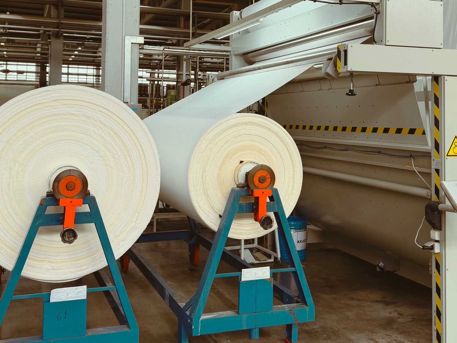 Rolls of nonwoven web feeding a needle-punching line — representative image